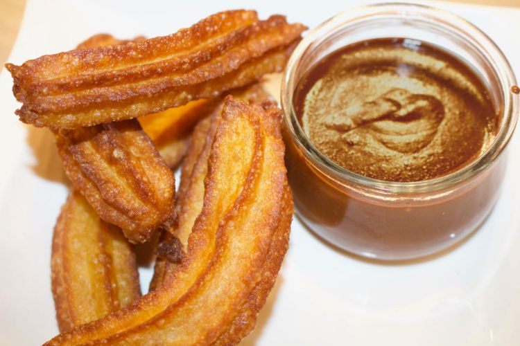 Traditionelle spanische Churros mit Schokoladensoße Traditionelle spanische Churros mit Schokoladensoße